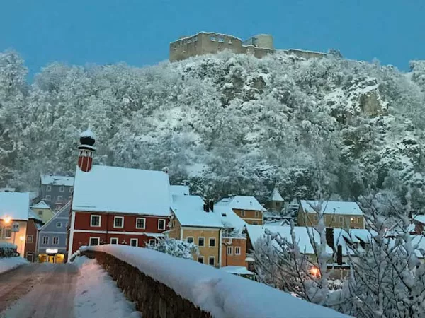 Blick auf die Burgruine von der verschneiten Steinernen Brücke